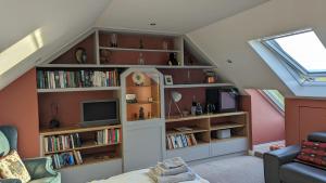 a attic living room with book shelves and a tv at Elegant Relaxed Studio in Maynooth