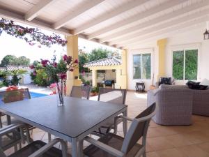 een patio met een tafel en stoelen en een woonkamer bij Selecta Casa Esmerdo in Estepona