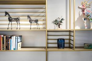 un estante con dos figuras de jirafas y libros en Two bedrooms flat with garden and free parking, en Tel Aviv