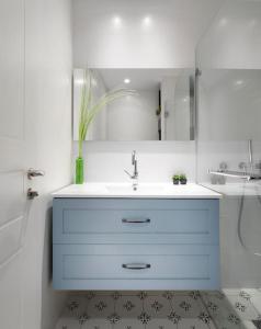 Baño blanco con lavabo y espejo en Two bedrooms flat with garden and free parking, en Tel Aviv