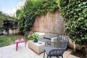 un patio con sofá, sillas y mesa en Two bedrooms flat with garden and free parking, en Tel Aviv