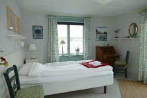 a bedroom with a bed and a desk and a window at Sundets Gård - Bed & Breakfast in Kopparberg