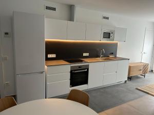 a kitchen with white cabinets and a sink at El Centre, 3 habitacions, 2 banys i cuina in L'Escala