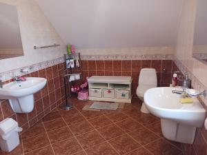 a bathroom with two sinks and a toilet at Pokoje Gościnne u Elżbiety in Sztutowo