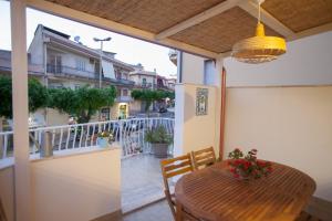 balcón con mesa de madera y sillas en Case degli Avi, camere nel Borgo marinaro, en Pozzallo