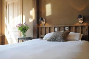 Un dormitorio con una cama blanca y un jarrón de flores. en B&B 1669, en Brujas