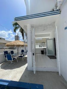 un patio con sillas, una mesa y una sombrilla en Janer House at San Juan, en San Juan