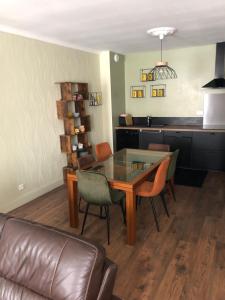 a living room with a glass table and chairs at Le 2 BIS in Langres