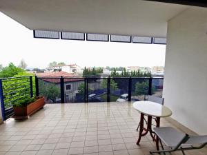 a large balcony with a table and chairs and a view at HomeAway Pescara Airport in San Giovanni Teatino +4 photos