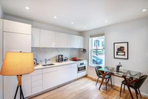 a kitchen with white cabinets and a table with chairs at Georgetown 1BR w bike storage nr Waterfront WDC-89 in Washington, D.C.