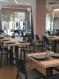 a dining room with wooden tables and chairs at Hotel Muccioli in Misano Adriatico
