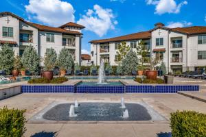 a courtyard with a fountain in front of some buildings at Astonishing CozySuites on I-35 with pool&parking #10 in Pflugerville