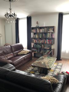 sala de estar con sofá de cuero y mesa de centro en Le 2 BIS, en Langres