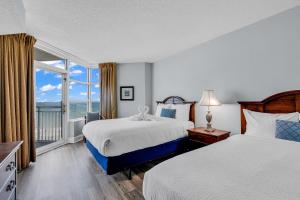 una camera d'albergo con due letti e una grande finestra di Breathtaking 2BR Condo w Floor-to-Ceiling Windows Overlooking Ocean a Myrtle Beach Altre 36 foto