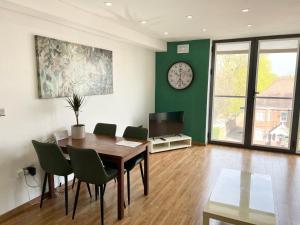 a dining room with a table and a clock on the wall at Castle Quarter Apartment with Free on site Parking in Bedford