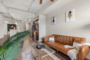 a living room with a couch and a palm plant at CozySuites Modern Midtown Condo 12 in Nashville