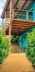 a blue house with a wooden deck and a table at Flat Noronha Dreams in Fernando de Noronha