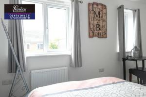 a bedroom with a bed and a window at Lovely Brand New 2 Bed House with Driveway Parking in Longford