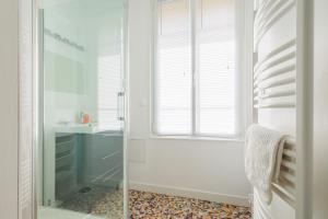 uma casa de banho com um chuveiro e uma cabina de duche em vidro. em LE CHEZY em Rennes