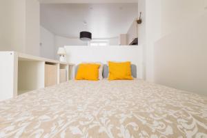 - une chambre avec un grand lit et 2 oreillers jaunes dans l'établissement LE CHEZY, à Rennes