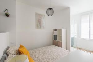 um quarto branco com uma cama e uma janela em LE CHEZY em Rennes