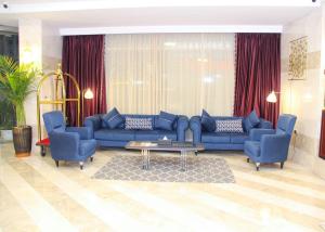 The Saj Hotel في عجمان: غرفة معيشة مع أرائك زرقاء وطاولة