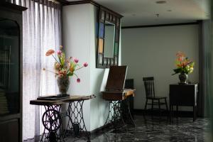 Cette chambre dispose d'une table avec des vases de fleurs. dans l'établissement Amanaki Thao Dien, à Hô-Chi-Minh-Ville