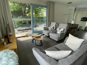 een woonkamer met een bank en stoelen en een raam bij Klipper in Terherne