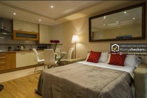 a bedroom with a large bed and a kitchen at Apartamento Cervantes Centro Historico in Salamanca