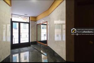 a hallway of a building with windows and a floor at Apartamento Cervantes Centro Historico in Salamanca