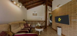 sala de estar con sofá y pared de ladrillo en Vistas al Valle, en Oreña