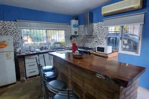 a kitchen with a large wooden counter and blue walls at Casa en el Campo con Pileta in La Granja