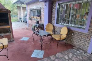 a patio with chairs and a table and a brick wall at Casa en el Campo con Pileta in La Granja
