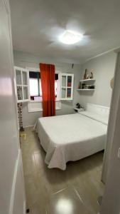 - une chambre avec un lit blanc et un rideau rouge dans l'établissement CASA OASI, à Playa Blanca