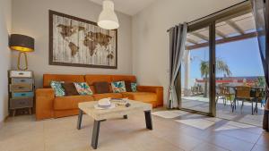 a living room with a couch and a table at Villa Del Corazon Salinas Golf in Caleta De Fuste