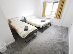 1 dormitorio con 2 camas y ventana en 2 Bedroom 2 Bath Apartment, sleeps 4, Town Centre en Wolverhampton