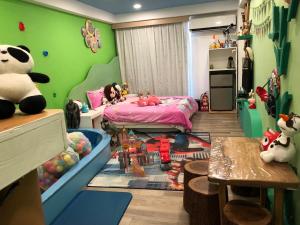 Dormitorio infantil con paredes verdes, cama y mesa en Kenting Mola, en Nanwan