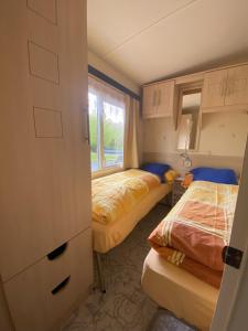 um pequeno quarto com 2 camas e uma janela em Ring Chalet em Brücktal