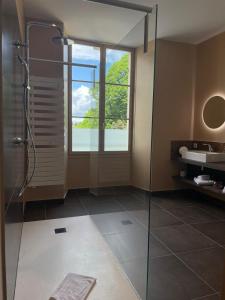 a bathroom with a glass shower and a sink at Hôtel & Restaurant - Le Manoir des Cèdres - piscine chauffée et climatisation in Rouffignac Saint-Cernin