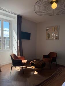 a living room with chairs and a table and a window at Hôtel & Restaurant - Le Manoir des Cèdres - piscine chauffée et climatisation in Rouffignac Saint-Cernin