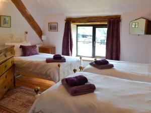 a bedroom with three beds and a window at Warmhill Farmhouse in Hennock