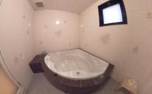 un bagno con ampia vasca e finestra di Hotel.COM (Adult Only) a Nagoya