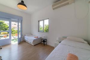 een witte slaapkamer met een bed en een raam bij Large 3 bedrooms a block from the beach in Tel Aviv
