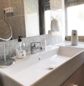 a white sink in a bathroom with a mirror at Vivienda rural Minas Home in Olleros de Sabero