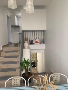 ein Wohnzimmer mit einem Tisch, Stühlen und einer Treppe in der Unterkunft Appartement en zone pavillonnaire in Drancy