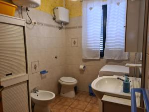 a small bathroom with a toilet and a sink at Casa in Centro in SantʼAntìoco