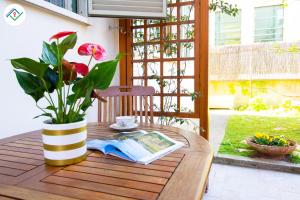 un tavolo con un libro e un vaso con una pianta di A Casa Di Rosa a Migliarino