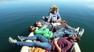 a group of people laying on a pier in the water at Uros Aruma-Uro on Uros Floating Islands in Puno