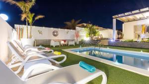 a villa with a swimming pool at night at Villa Amatista Salinas Golf & Beach in Caleta De Fuste