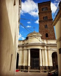 eine Kirche mit einem hohen Turm und einer Uhr in der Unterkunft Relais il Duomo con SPA privata in Sutri